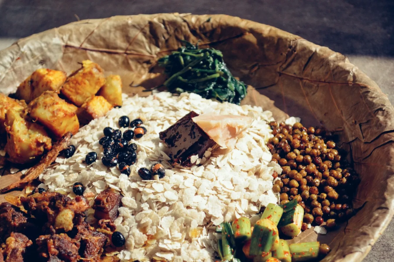 A Newari bhoj of beaten rice, choila, bara, beans and achar served on a leaf plate